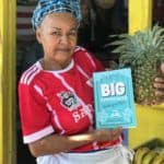 Ambergris Caye Fruit Stall Lady holding Rebecca's book