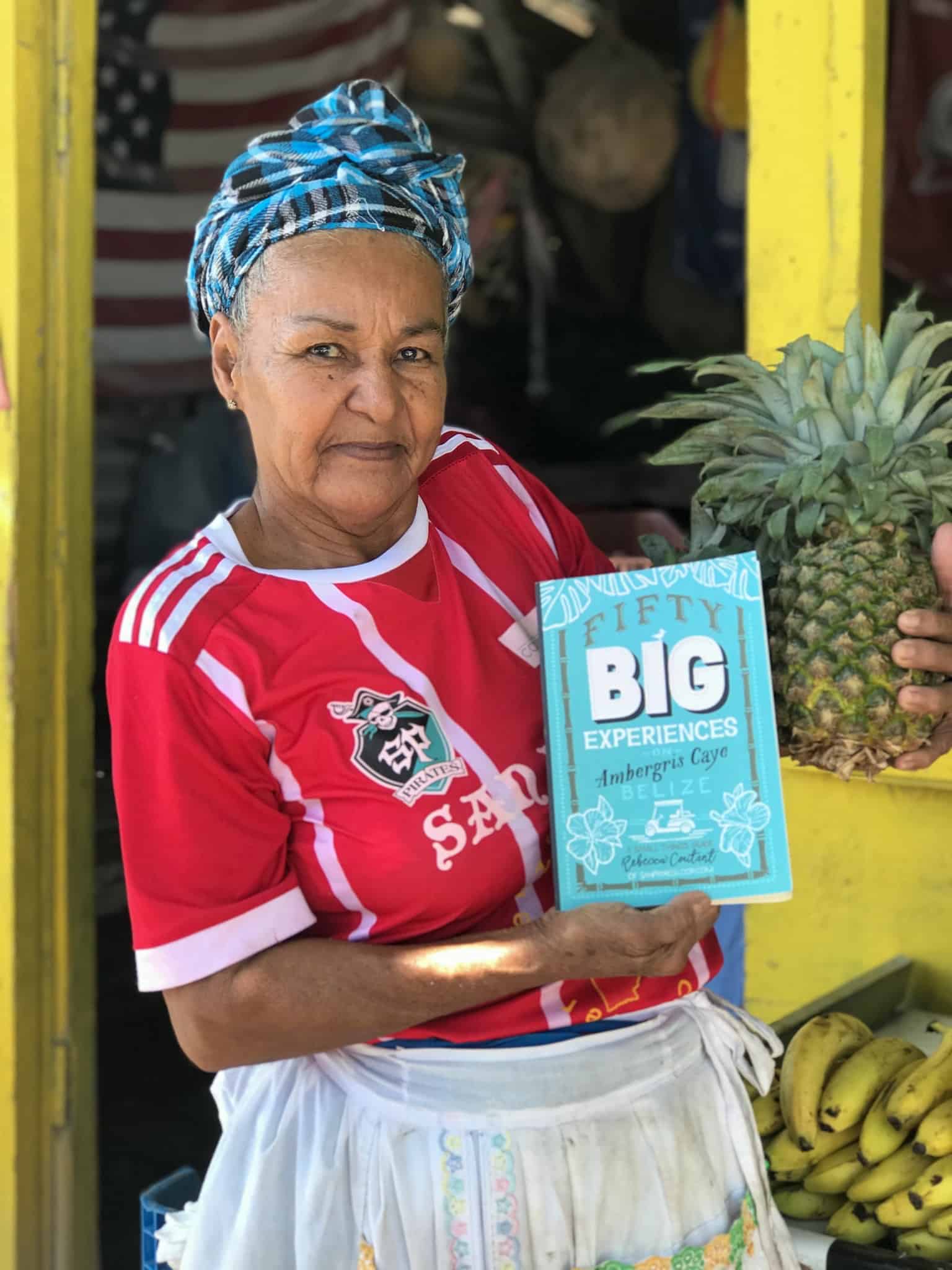 Ambergris Caye Fruit Stall Lady holding Rebecca's book